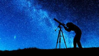 Silhouetted figure using the best telescopes for astrophotography to study the night sky