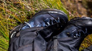 A pair of feet wearing gaiters and a pair of Salewa Mountain Trainer 2 Mid Gore-Tex Boots.