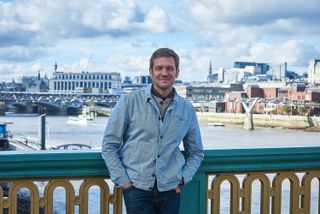 Charlie Luxton standing on a bridge over the Thames