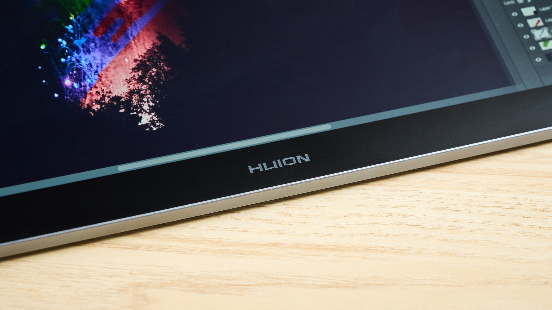 A closeup of the bottom of the Huion Kamvas Pro 19's screen featuring artwork of recolored fireworks.