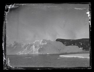 An iceberg and land at Ross Island, Antarctica in a photograph taken between 1914 and 1917 and only recently developed.