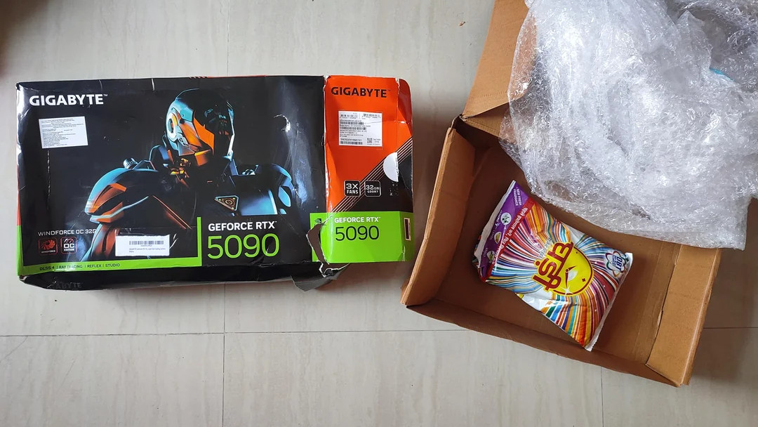 A Gigabyte RTX 5090 box that looks battered, open and showing a packet of laundry detergent inside