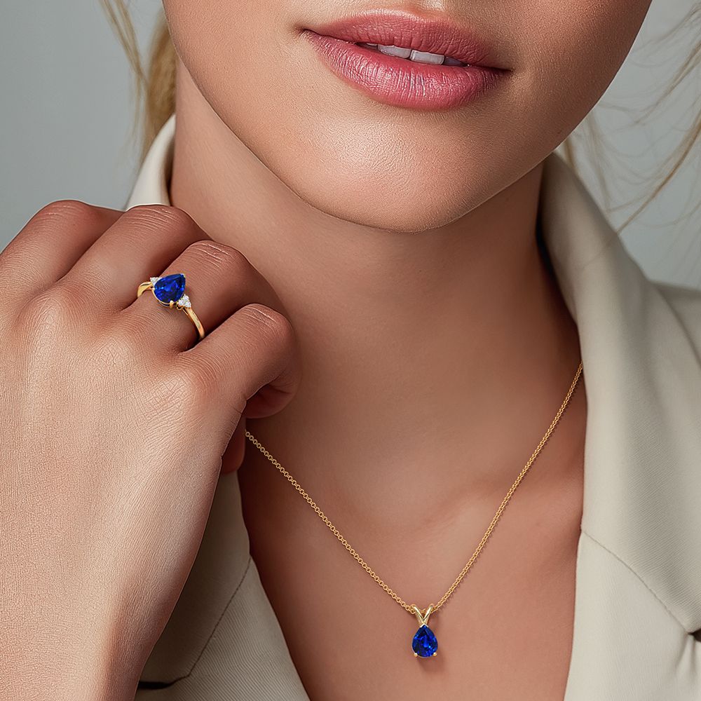 Model wearing a gold necklace and ring with blue lab grown diamond sold at Angara