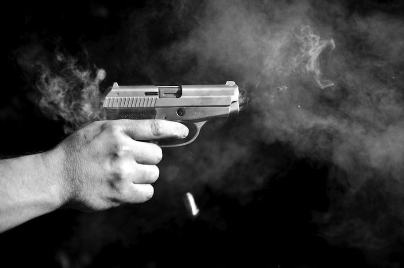 Firing a handgun in black and white