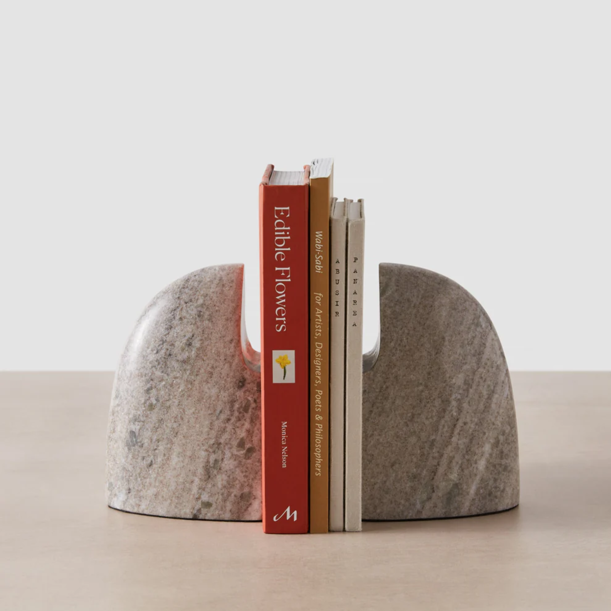 marble bookends holding up four books