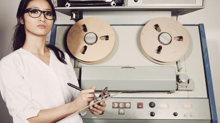 Young female scientist checking computer, 60s/70s vintage style.