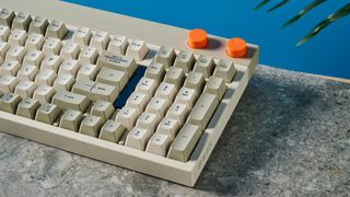 The Lofree Block keyboard on a stone surface with a blue wall in the background.