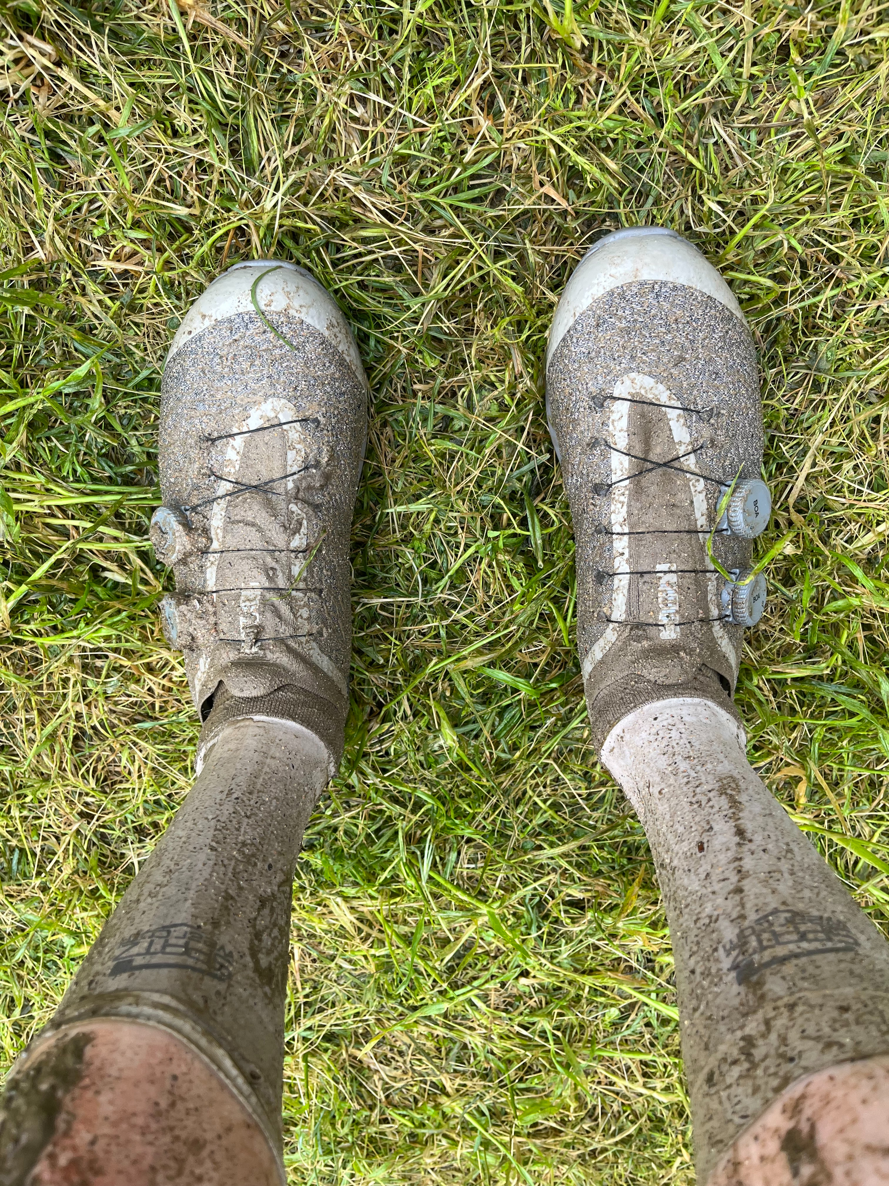 A pair of Rapha Pro Team Gravel shoes covered in mud