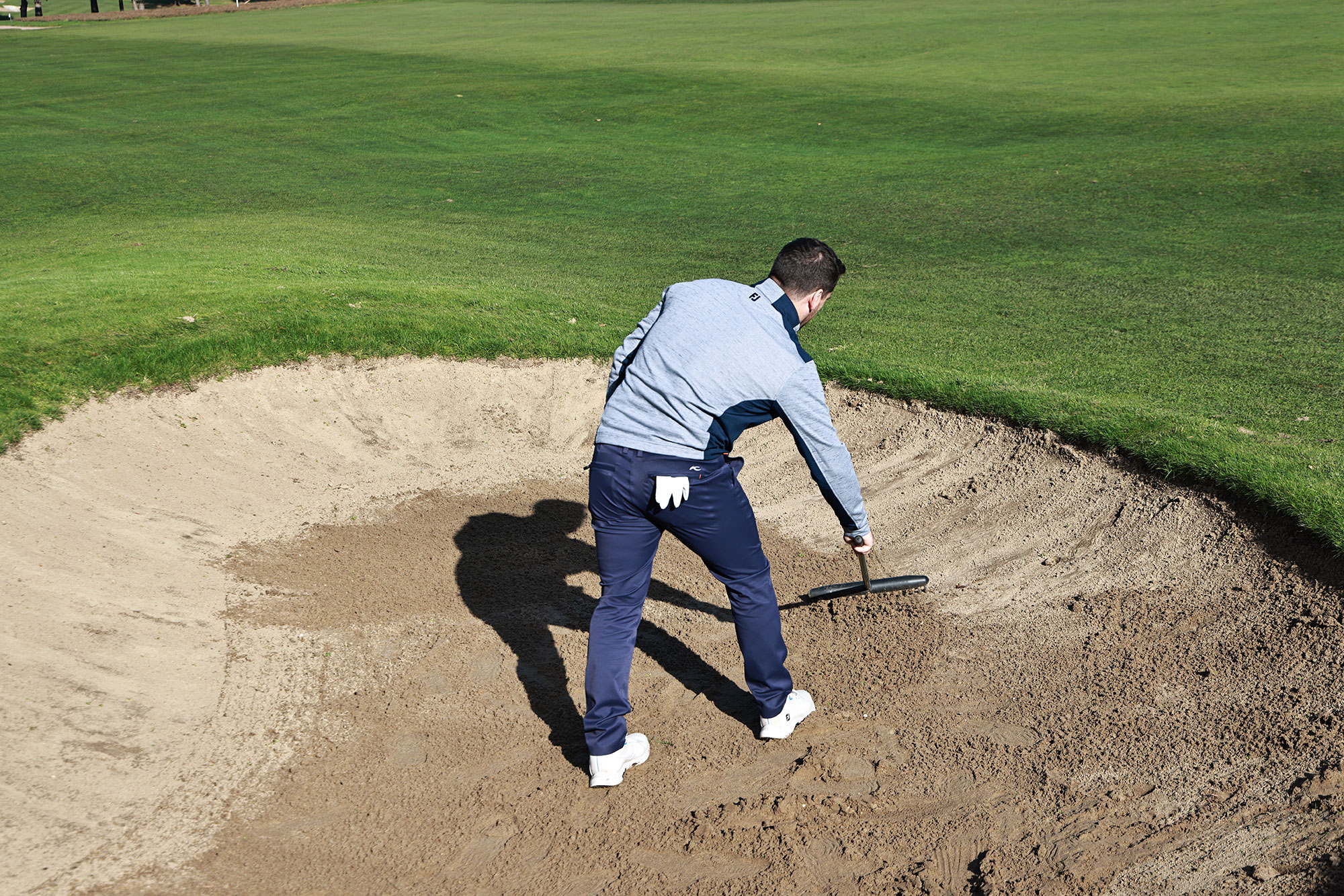 Sam De'Ath raking a bunker on his own