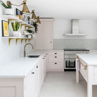 a baby pink kitchen with range cooker and open shelving