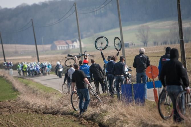 Mechanics wait as the race comes back down from the climb of the Kwaremont.