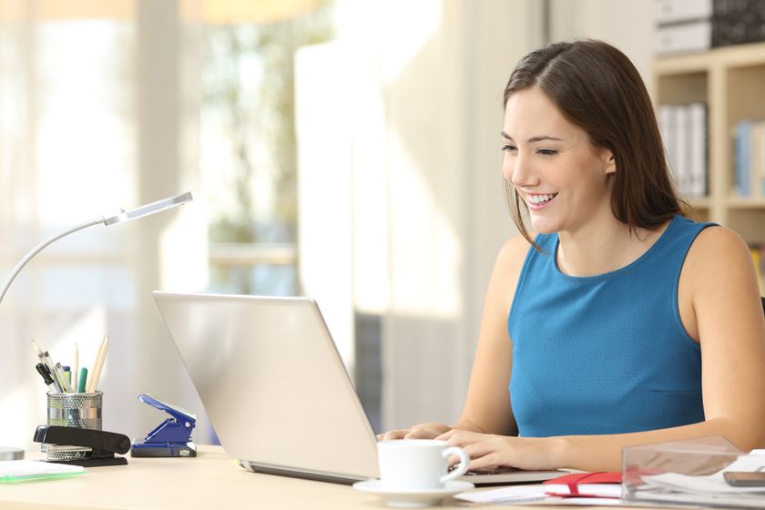 A woman sitting at a computer and smiling