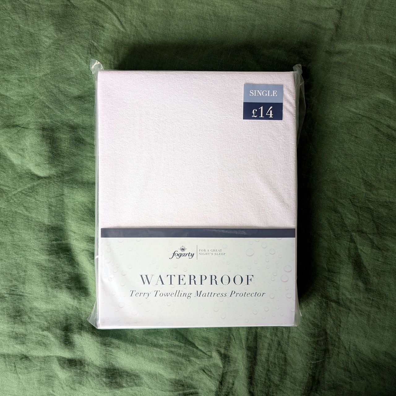 Dunelm forgarty mattress topper folded up in plastic packaging with a white card label.