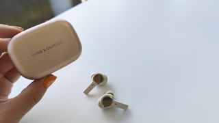 Bang & Olufsen Beoplay EX review: woman holding true wireless earbuds case