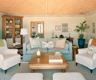 Living room with blue sofa and two armchairs and terracotta ceiling