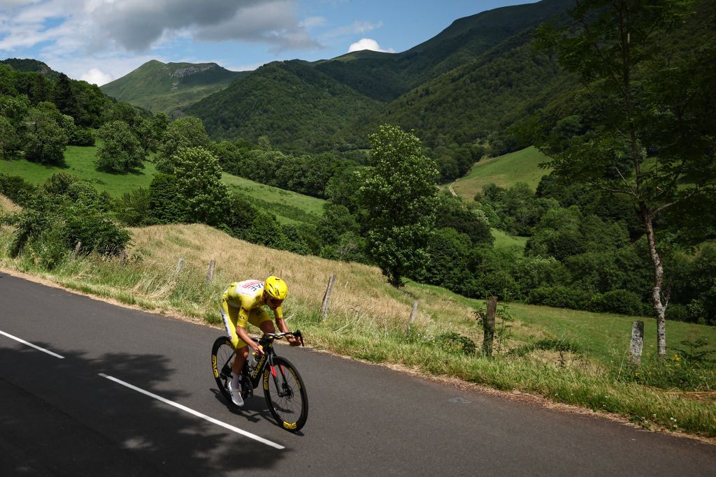 UAE Team Emirates team's Slovenian rider Tadej Pogacar wearing the overall leader's yellow jersey cycles in a lone breakaway in the descent of the Pas de Peyrol (Puy Mary) during the 11th stage of the 111th edition of the Tour de France cycling race, 211 km between &Atilde;vaux-les-Bains and Le Lioran, on July 10, 2024. (Photo by Anne-Christine POUJOULAT / AFP)