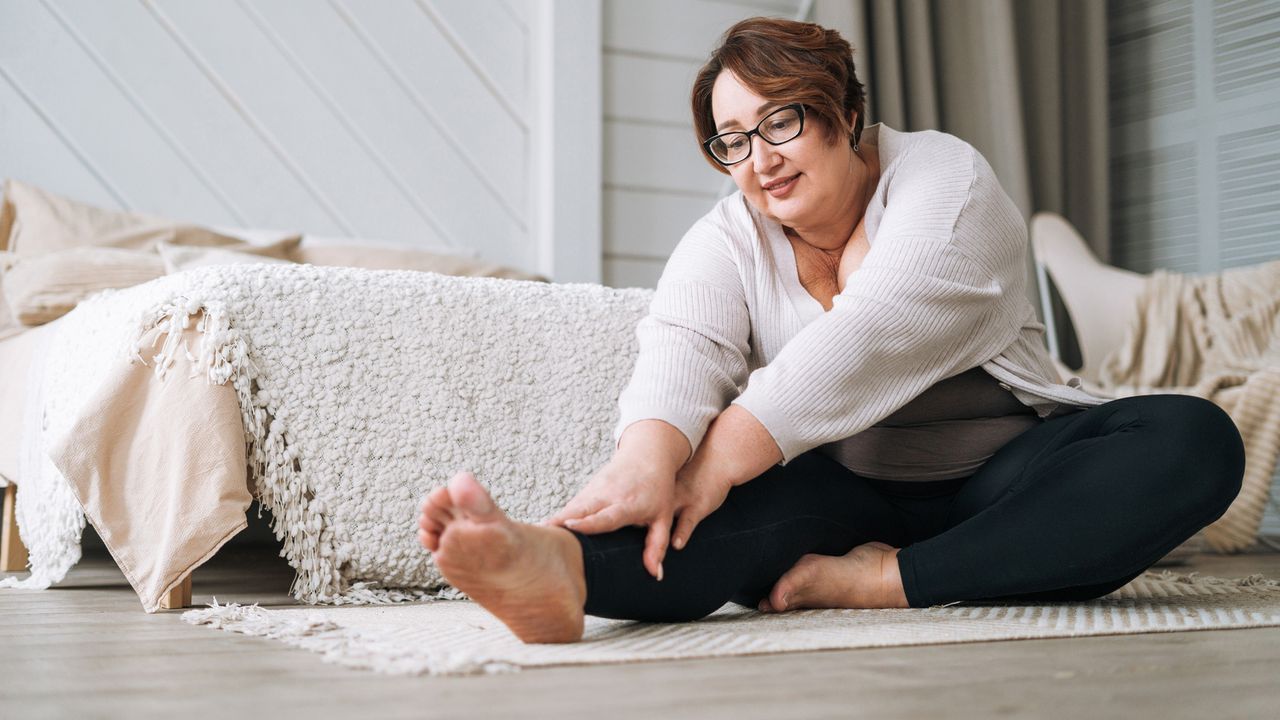 Woman stretching at home on yoga mat