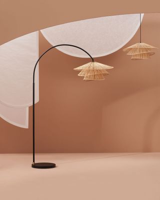 A arc shaped lamp with a floral rattan shade