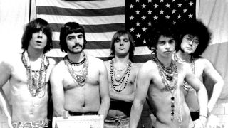 The MC5 standing topless in front of a US flag