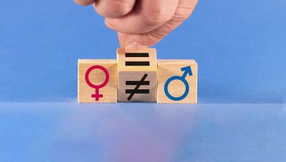 A hand changes an unequal sign to an equal sign between male and female symbols