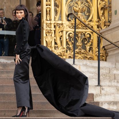 Zendaya wearing a long sleeve black dress with a long train to Schiaparelli Haute Couture show in Paris