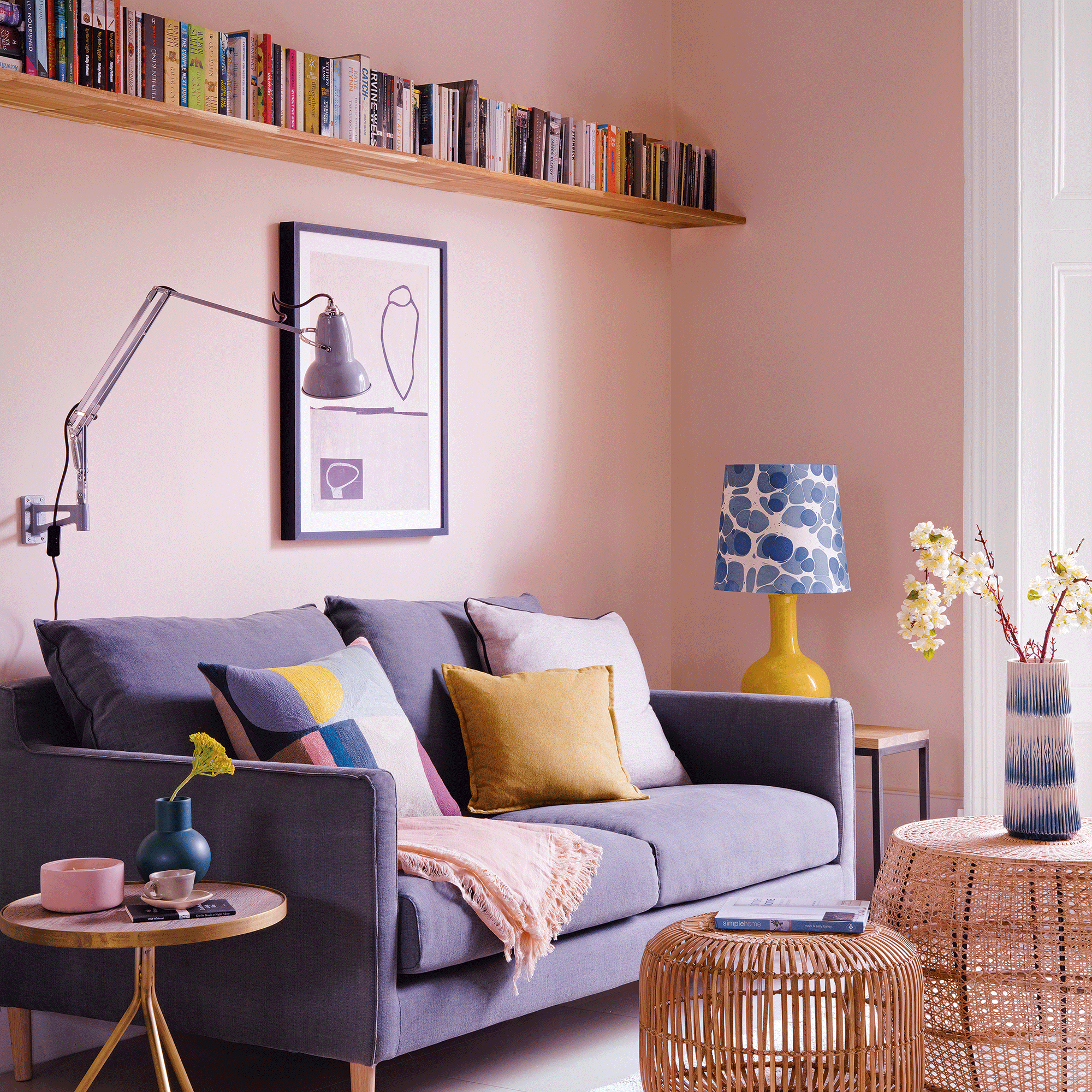 Pink living room with blue sofa and bookshelf