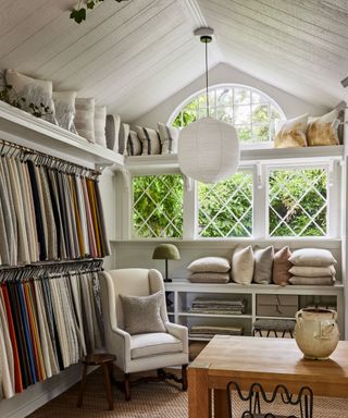 White armchair, wooden table, white shelves