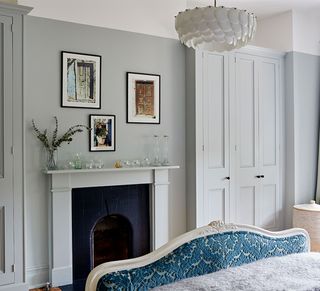 Grey bedroom with alcove wardrobes, pendant light and fireplace