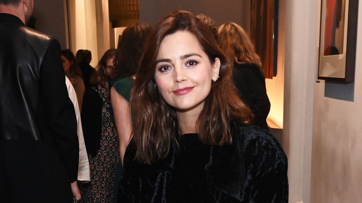 Jenna Coleman with her hair wavy and a black top at a press night 