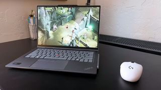 The Lenovo ThinkPad X1 2-in-1 Gen 9 sitting on a black desk with a white mouse running Death's Door