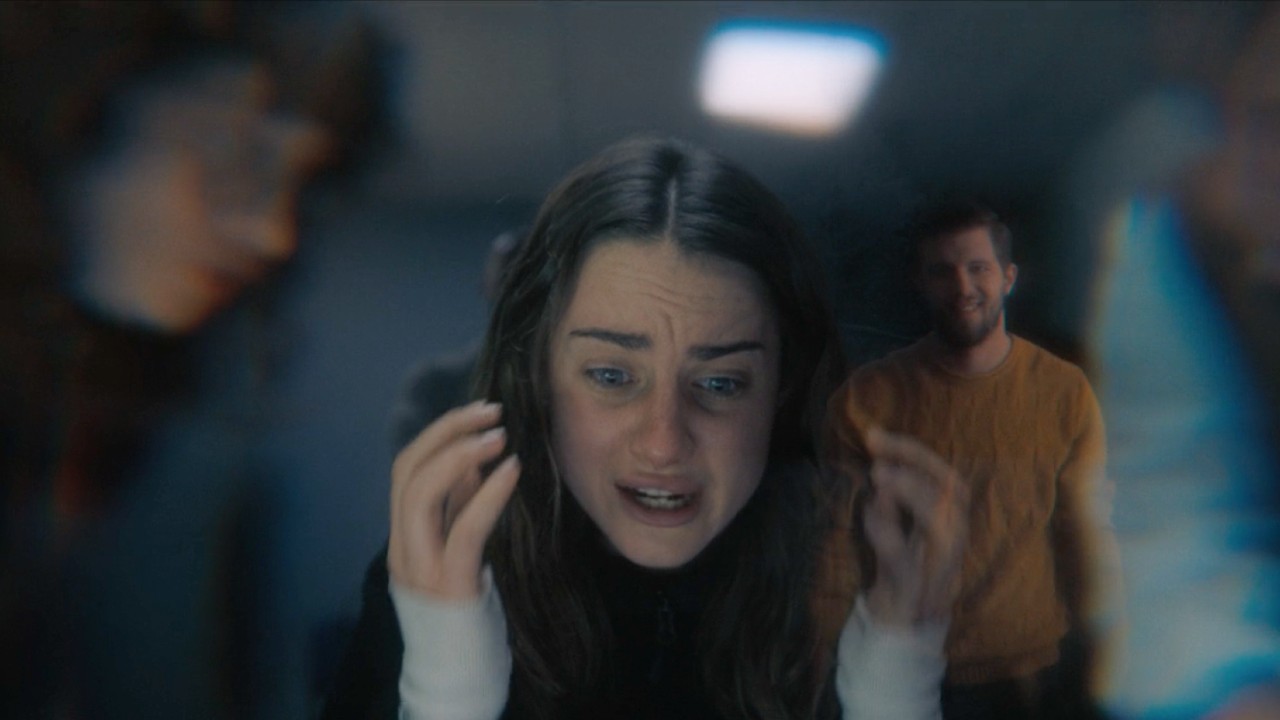 Grace Van Patten as Amanda Knox freaking out while blurred figures stand around her.