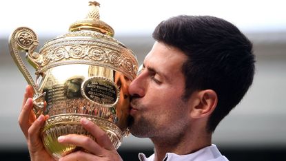 Novak Djokovic kisses the winner’s trophy after beating Roger Federer in the Wimbledon final 