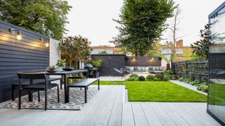 modern garden with outdoor furniture and dark painted timber fencing