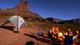 Campers cook dinner under a star-laden sky on the White Rim trail