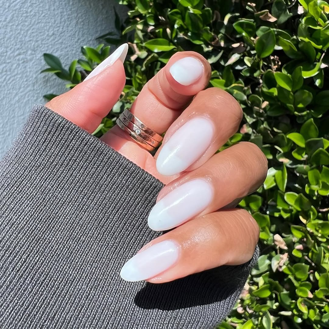 A person wearing a milky white manicure.