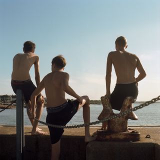 Three white boys about to jump in the sea