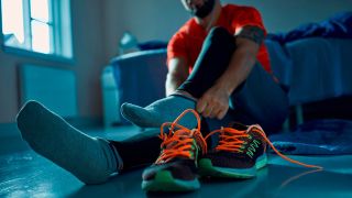 Man pulling on running socks