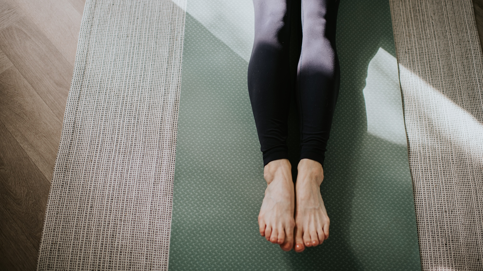 Woman stretching legs on yoga mat