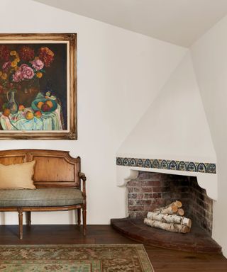 bedroom corner fireplace with original tiles and small wood frame sofa