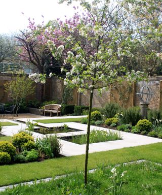 Walled garden design with paved and cobbled features, fruit trees and mixed planting