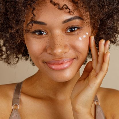 Best eye creams - best eye cream - close up of a black woman with curly hair applying eye cream