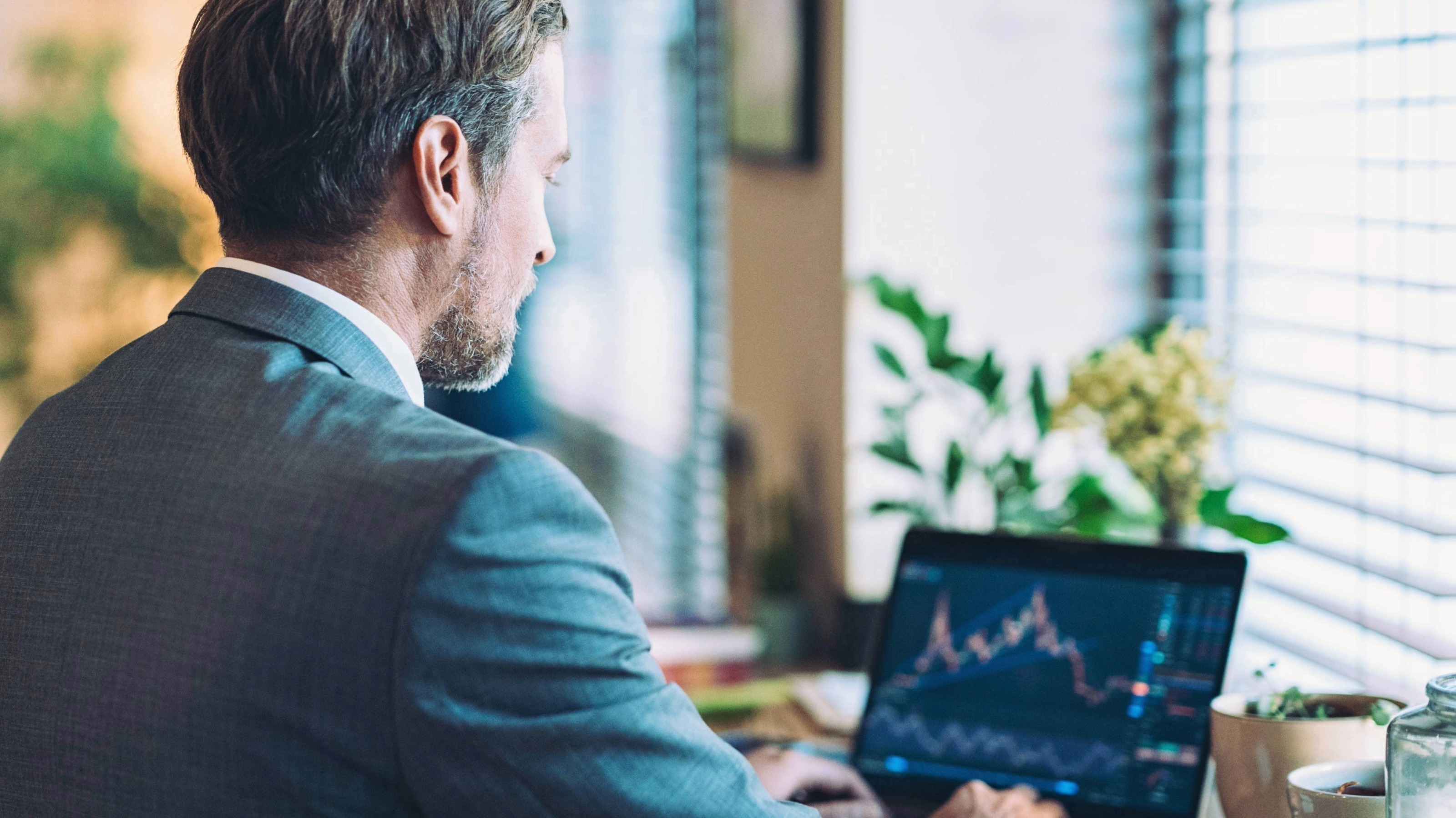 Businessman checking financial data on laptop