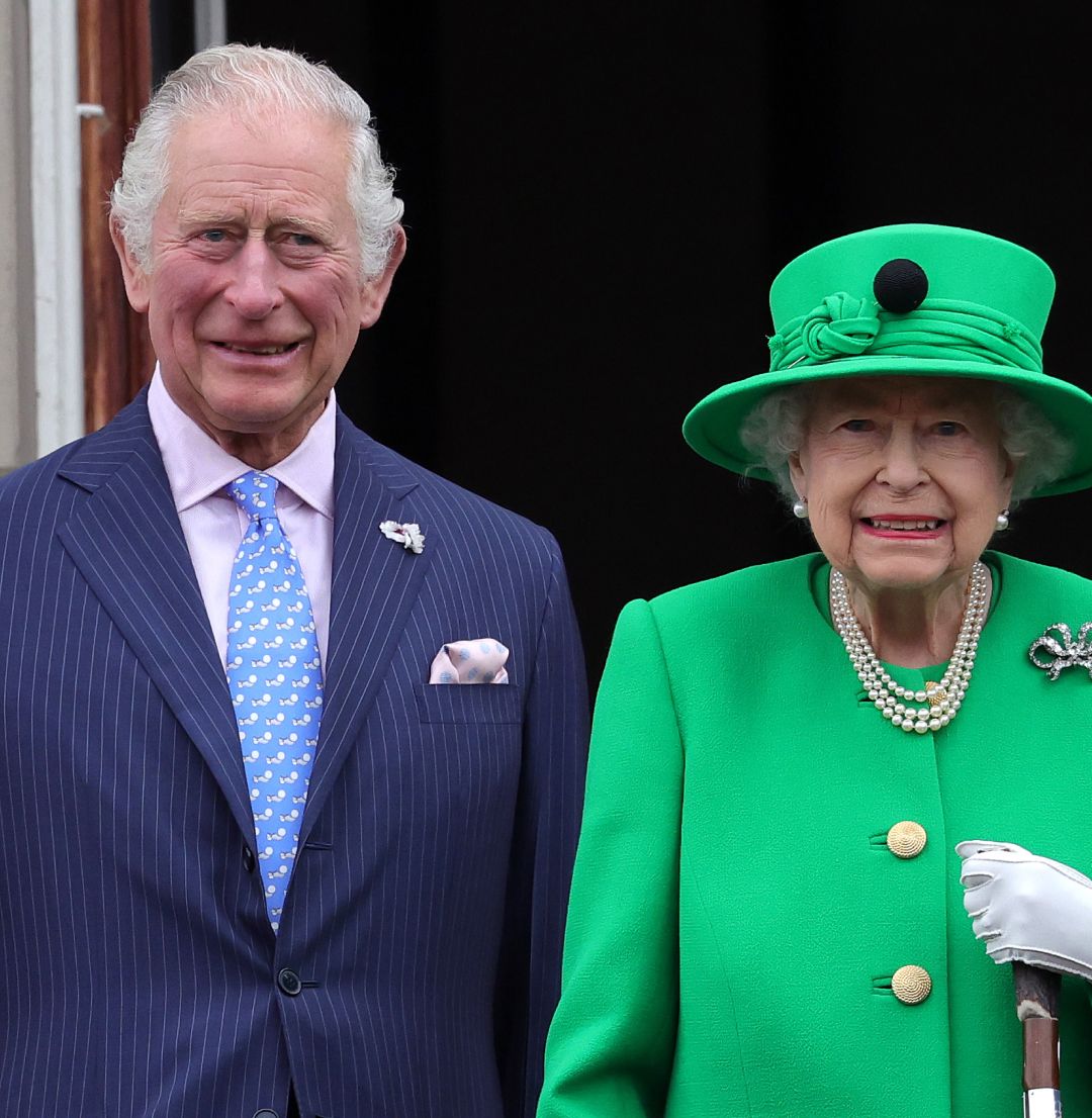 Prince Charles and Queen Elizabeth standing next to each other and smiling