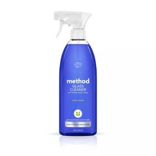 A side-on bottle of a clear bottle of method glass cleaner with blue liquid