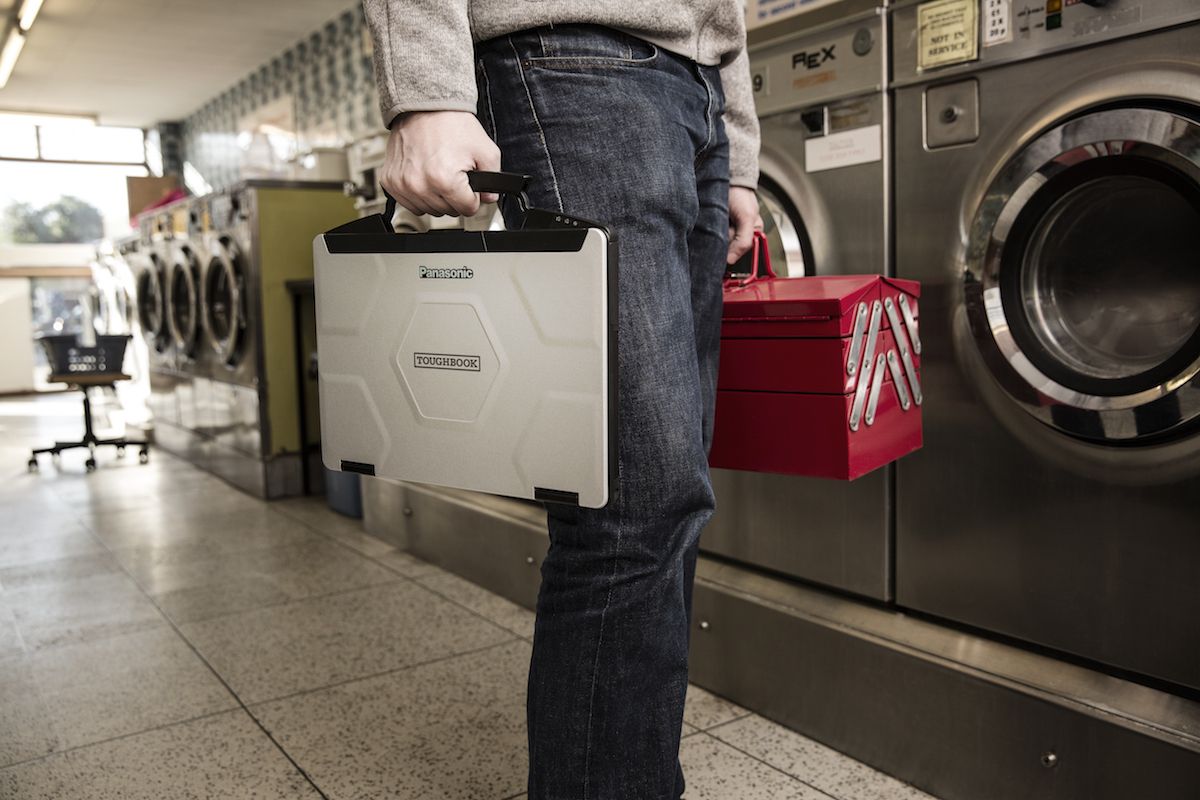 Gentleman holding a Panasonic Toughbook in front of household appliances