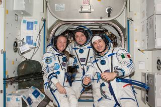 Russian cosmonaut Fyodor Yurchikhin (center), Expedition 37 commander; along with NASA astronaut Karen Nyberg and European Space Agency astronaut Luca Parmitano pose for a crew portrait while wearing their Russian Sokol spacesuits.