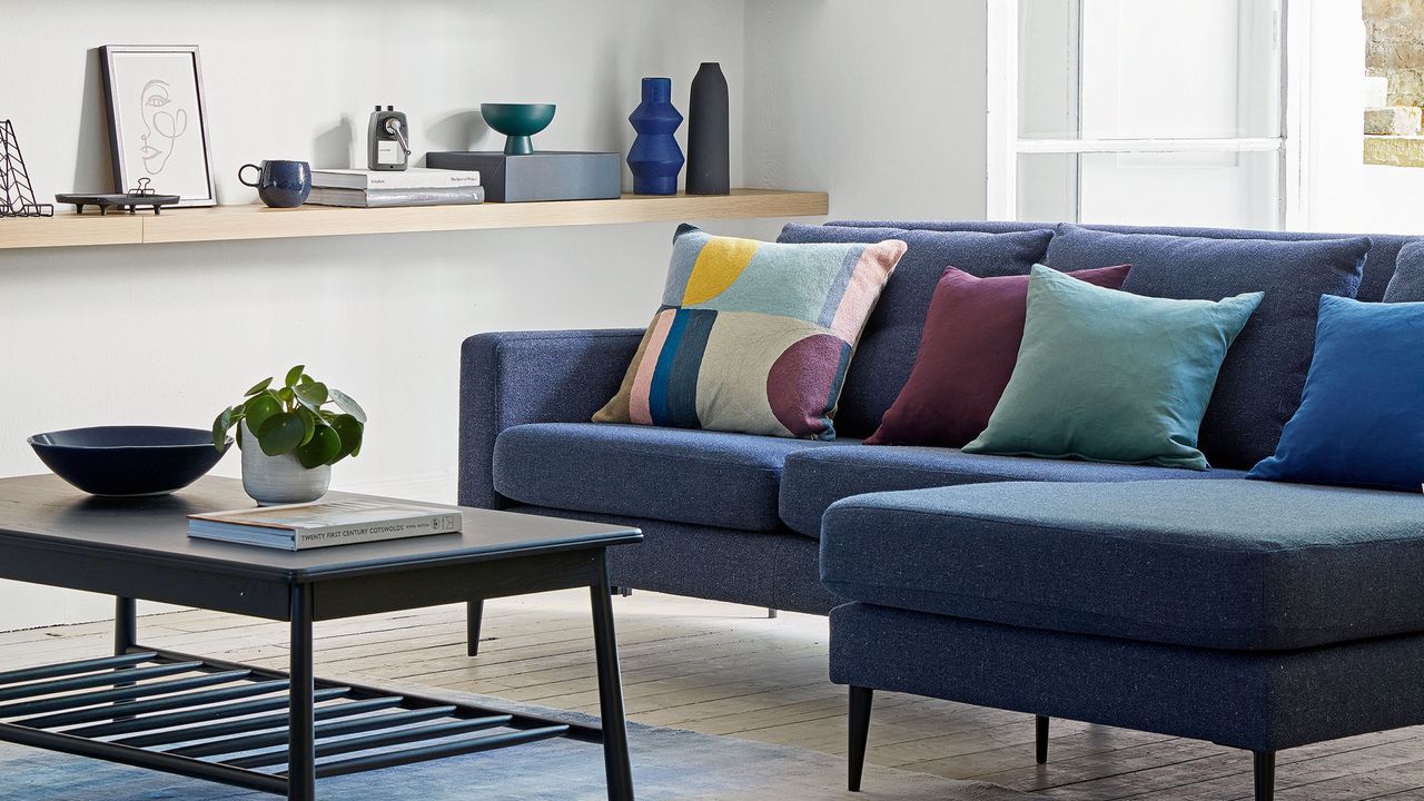 White living room with wooden floors and navy corner sofa