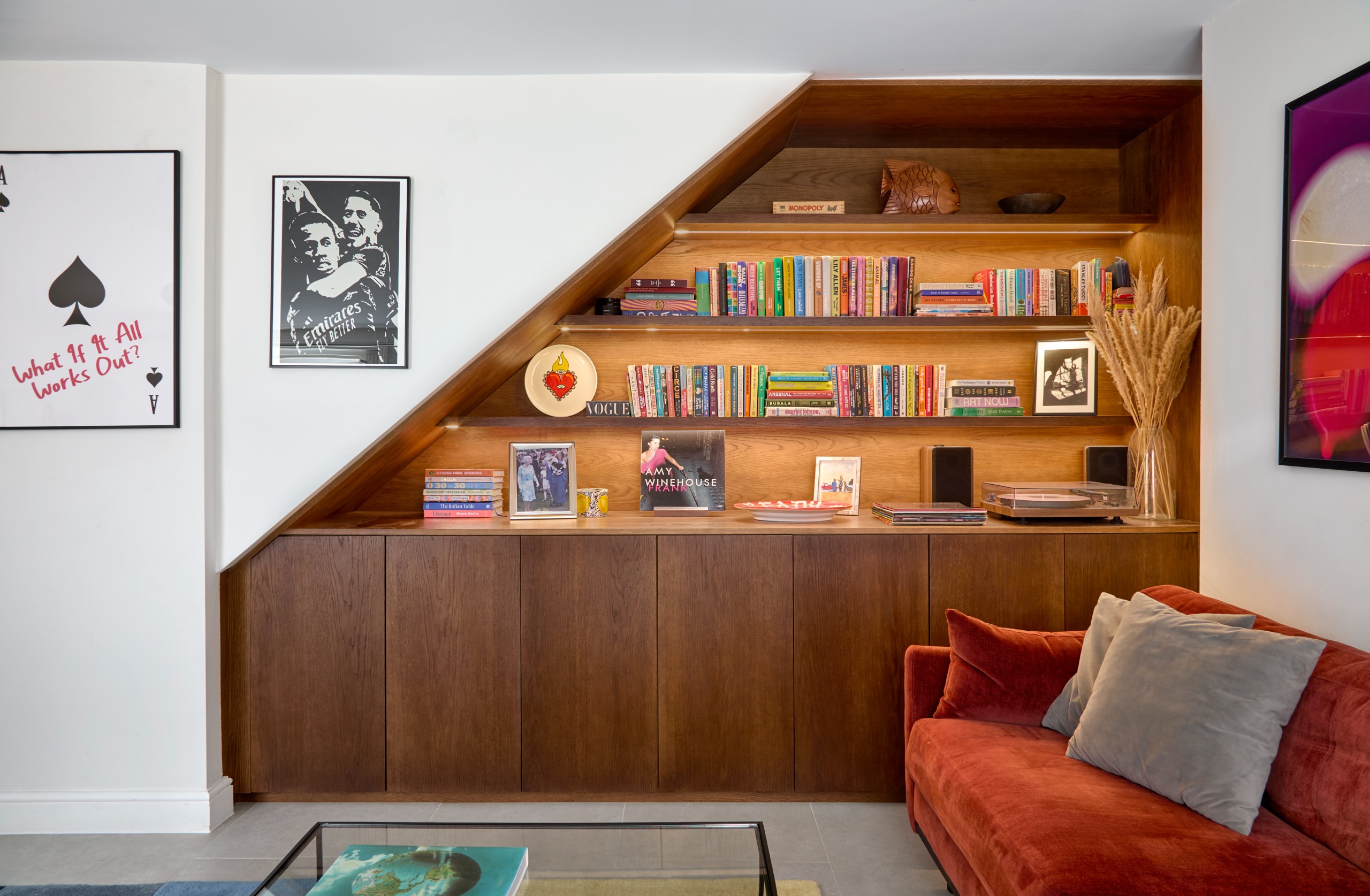 living room with sleek wooden cabinetry built-in, and a rust coloured sofa
