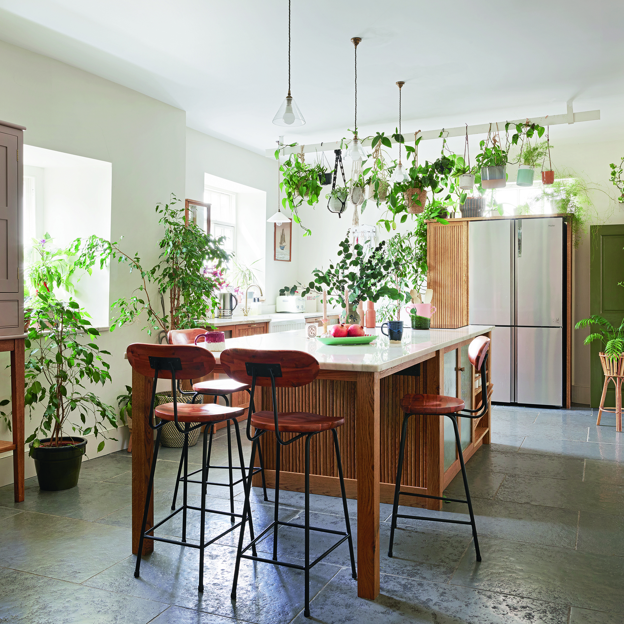 Kitchen with wooden ribbed cabinets, island and indoor plants
