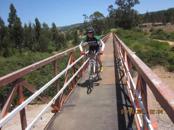 Mary McConneloug rides a foot bridge in the middle of nowhere.